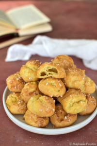 L'assiette de chouquettes dont celle du dessus qui a été mordue pour laisser voir l'intérieur aéré