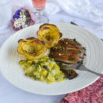 L'assiette dressée comprenant le steak de champignon, la fondue de poireau et deux roses de pomme de terre